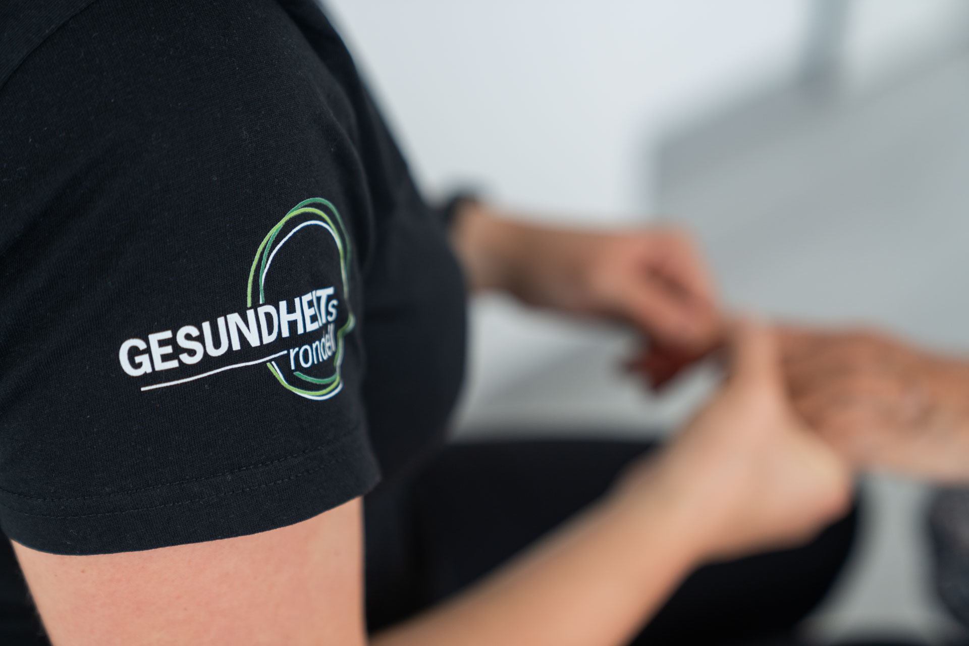 Ergotherapeutin hält Hände eines Patienten bei der Behanldung in der Praxis des Gesundheitsrondells in Waiblingen